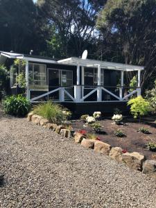 阿卡罗阿Hideaway - A Couples Retreat的一座白色的小房子,前面设有一个花园