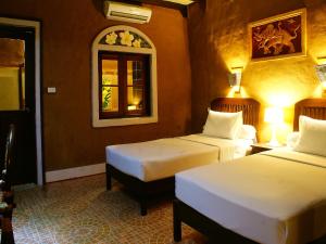 Ban Khon萨拉多恩科恩酒店的酒店客房,设有两张床和镜子