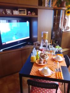 瓦伦纳奥瑞兹之家住宿加早餐旅馆的一张桌子,里面有食物和电视