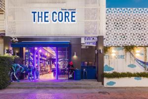 清迈The Core Street By Stay Now - SHA Plus的门上标有紫色标志的商店前