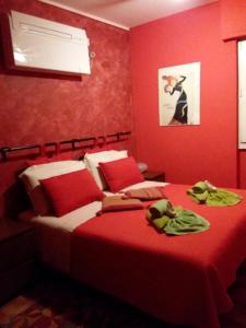 瓦伦纳奥瑞兹之家住宿加早餐旅馆的一间卧室设有红色的墙壁和一张带毛巾的床