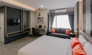 乌汶Arista Hotel Ubon的配有一张床和一张书桌的酒店客房