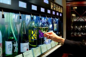神户神户三宫方丹别墅酒店的一个人拿着一杯葡萄酒
