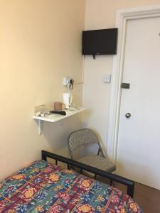多佛尔隆菲尔德旅馆的卧室配有床、椅子和门