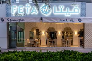 迪拜Jannah Marina Hotel Apartments的大楼内带桌椅的餐厅