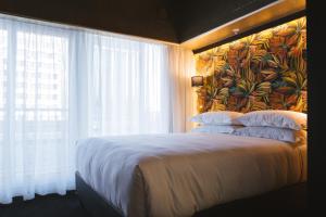 开普敦Signature Lux Hotel by ONOMO, Foreshore的一间卧室设有一张大床和大窗户