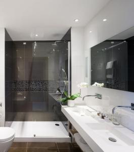 伊索拉阿尔巴勒拉Isola di Albarella Golf Hotel的一间带两个盥洗盆、淋浴和卫生间的浴室