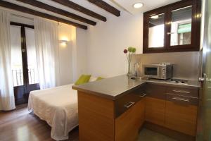 巴塞罗那BCN入住公寓酒店的带微波炉的厨房和客房内的床铺