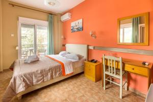 阿吉亚特拉萨阿尔米拉酒店的一间卧室设有橙色的墙壁、一张床和一张书桌