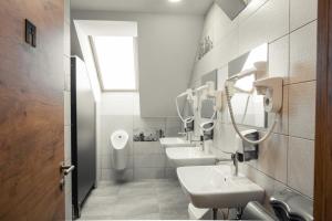 斯洛文尼亚格拉代茨Hostel Vila Pohorje的浴室设有3个水槽和2面镜子
