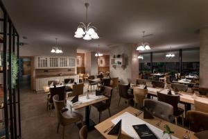 斯洛文尼亚格拉代茨Hostel Vila Pohorje的餐厅设有木桌和椅子及灯