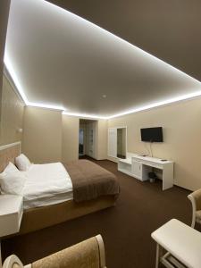 基辅欧宝龙酒店的一间带大床和电视的卧室