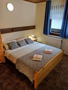 克拉尼斯卡戈拉Apartma Kramar Podkoren的一间卧室配有一张大床和两条毛巾