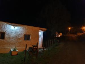 RacoCasas de Raco的夜间的房子,旁边停着一辆摩托车