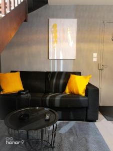 雷恩Appartement Le 146 Bis, avec Parking的客厅里一张带黄色枕头的黑色沙发