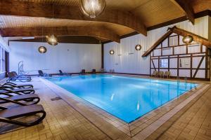 佩尔莱贝格诺伊尔亨宁斯霍夫运动康体度假酒店的一座大型游泳池,四周摆放着椅子