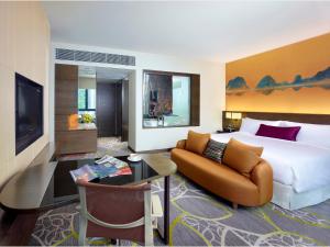 香港香港九龍東皇冠假日酒店的酒店客房设有一张大床和一张沙发。