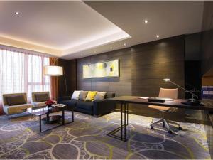 香港香港九龍東皇冠假日酒店的客厅配有书桌和沙发。