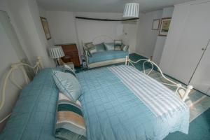 霍尔特Buttercup Cottage的一间卧室配有一张大床和一把椅子