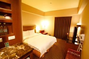 台东康桥商旅-台东馆的酒店客房,配有床和电视