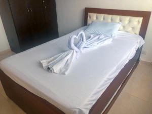 吉拉尔多特Sensacional Apartamento Reserva Peñon Girardot的一张带白色床单和毛巾的床