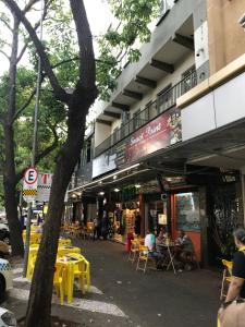 伊瓜苏Edifício Río Mar的街道上一座配有黄色桌椅的建筑