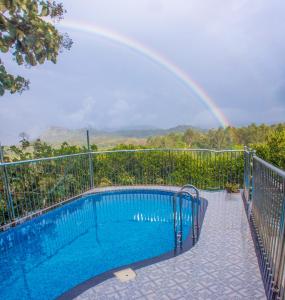 提喀迪Chrissie's Hotel的游泳池上方的彩虹