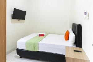 梭罗RedDoorz Syariah near Purwosari Train Station的一间带一张床的卧室,位于带电视的客房内