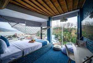 归仁Mira Bãi Xếp Quy Nhơn - The Hidden Jewel的一间卧室设有一张床和一个大窗户