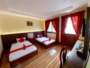 金边首都一号旅馆的酒店客房,设有两张床和红色窗帘