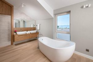 巴什卡沃达Villa Basca的浴室配有大型白色浴缸和2个盥洗池