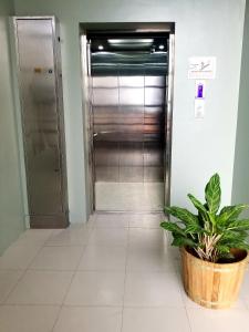 达沃市安克拉酒店的走廊上设有电梯和盆栽