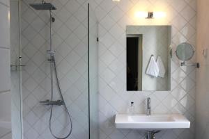 MäntsäläHotelli Kartanon Meijeri的带淋浴、盥洗盆和镜子的浴室