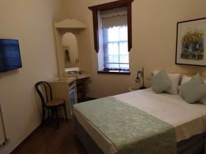 安塔利亚明杨酒店的一间卧室配有一张床、一张书桌和一个窗户。