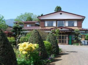 富士河口湖Minshuku Iwaki的前面有一堆灌木的房子