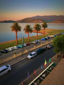 奥尔贝泰洛Hotel Relais I Presidi的停车场有一堆汽车和棕榈树