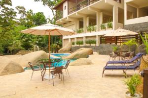 里约热内卢Casa Pedra Bonita的庭院配有椅子和桌子及遮阳伞
