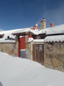 San Martín de la Vega del AlbercheCASA RURAL GREDOS的一座被雪覆盖的建筑,上面有标志