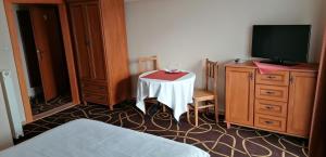 特伦钦马格诺利娅膳食公寓酒店的客房设有桌子、电视和床。