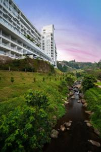 普卡Le Eminence Puncak Hotel Convention & Resort的建筑物前的一条河流