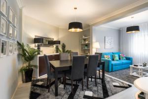 加亚新城Metropolitan Gaia-Porto的一间带桌子和蓝色沙发的用餐室