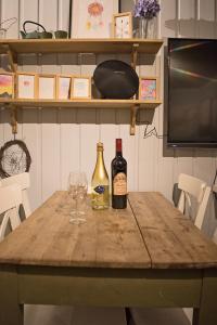 海姆瑟达尔Koselig Hytte i Hemsedal的一张桌子,上面放有两瓶葡萄酒和一杯
