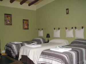 Vista FloresLa Posada Del Jamón的带绿色墙壁的客房内的三张床