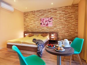 布拉迪斯拉发维克托酒店的卧室配有一张床和一张桌子及椅子