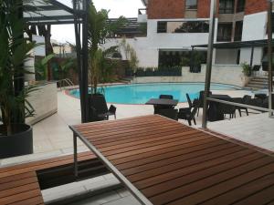 内罗毕Longonot Place Serviced Apartment-Nairobi, City Centre CBD的一个带木桌和游泳池的庭院