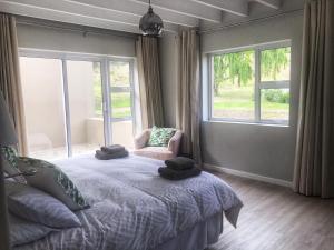 斯特尔拜The Suites at Waterryk Eco Guest Farm的一间卧室配有一张床、一把椅子和窗户。