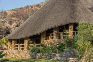 KamanjabOndundu Lodge的一座石头建筑,有草屋顶