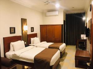 伊斯兰堡Hotel One Jinnah, Islamabad的酒店客房设有两张床和电视。