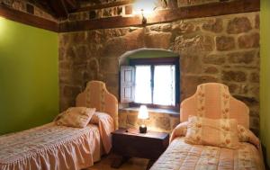 CillamayorCasa Rural La Panera的一间卧室设有两张床和石墙