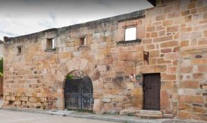 CillamayorCasa Rural La Panera的旧砖墙,有门和门